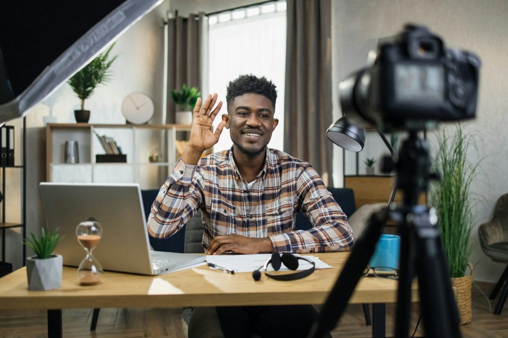 African man recording educational seminar on video camera