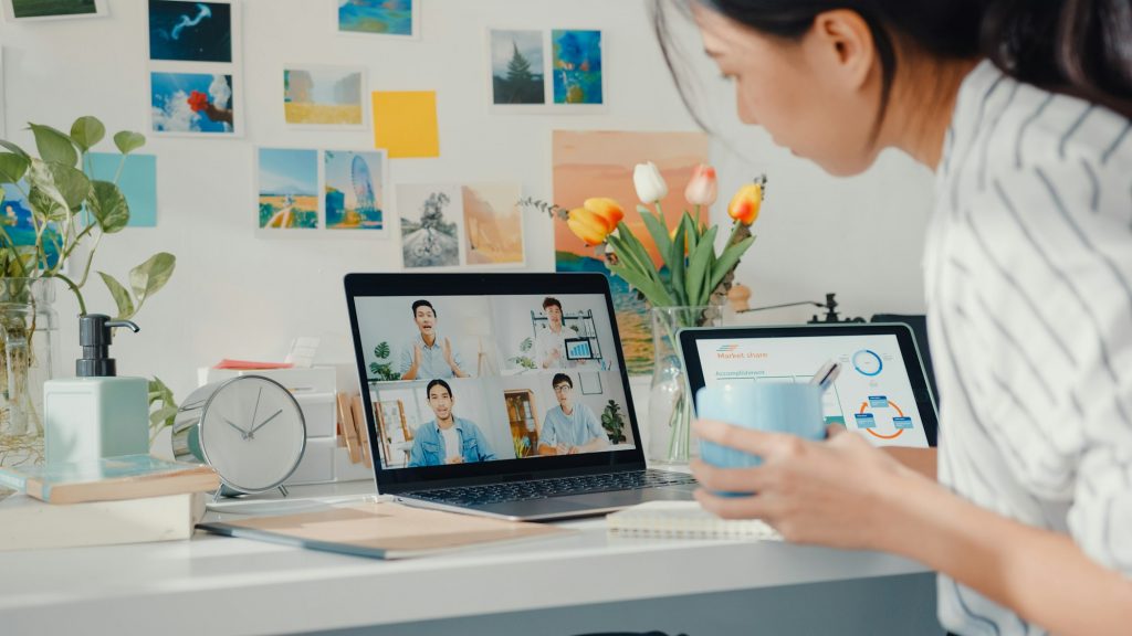 Young asia female employee listen leader on video call with colleagues with laptop at home.