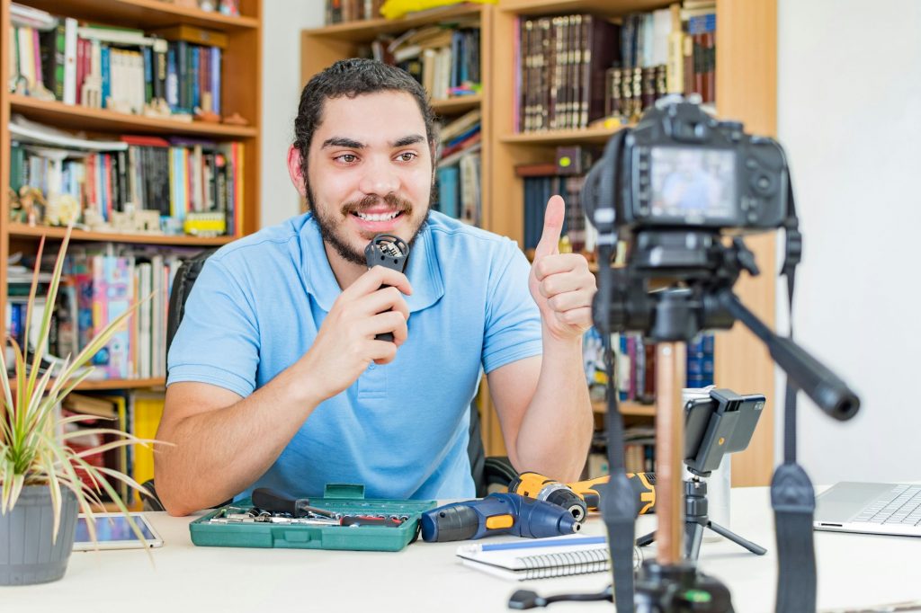 Young Caucasian man making a vlog and interacting with viewers - working from home concept